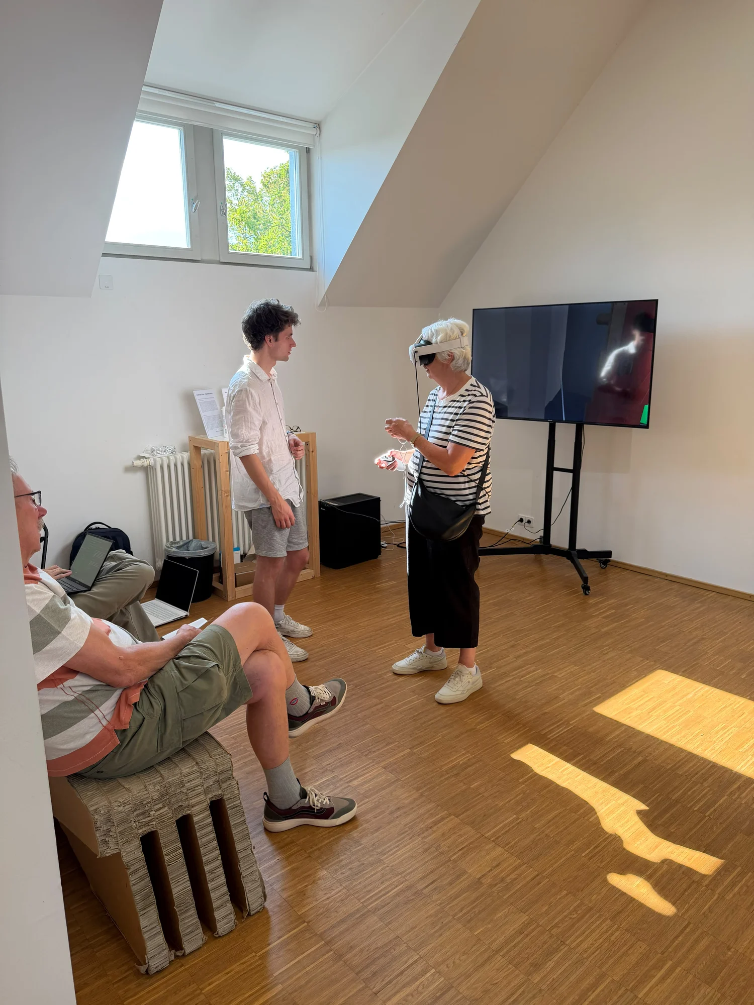 A visitor using the Hermann Sprauer VR station while the exhibition team monitors the experience